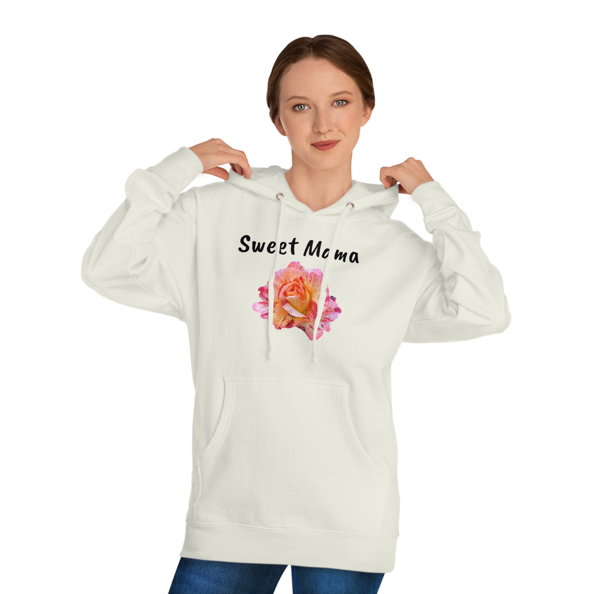 A woman wearing a Printify Sweet Mama Hooded Sweatshirt with "sweet mama" printed above a vibrant pink rose, pulling the hood's drawstrings, looking at the camera.