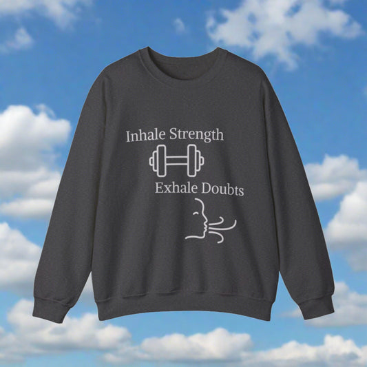 A charcoal gray motivational sweatshirt featuring the phrase "Inhale Strength Exhale Doubt - w graphics" with a dumbbell icon above, and "exhale doubts" with an icon of a person meditating below, set against Printify.