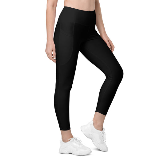 A person is standing in a side pose wearing Blue Sky Runner Leggings with pockets - Women's from Blue Sky Runners and white sneakers. Their upper torso is not visible. The leggings feature convenient side pockets. The background is plain and white.